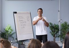 BSL teacher standing near a flip board