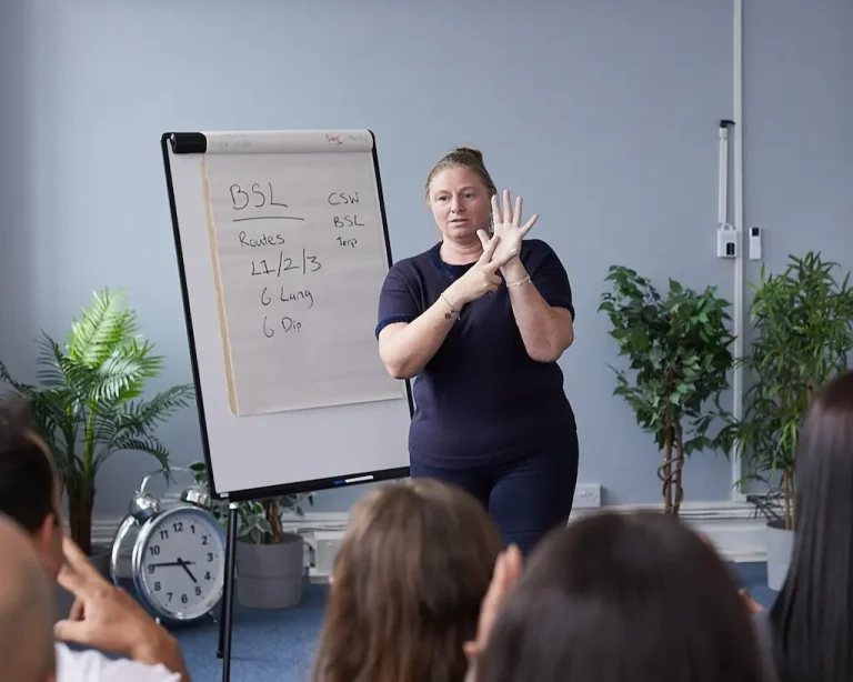 Sign language teacher in front of a flipchart.