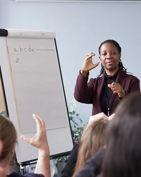 Sign language teacher in front of whiteboard